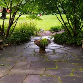 Stone retaining wall with planting above a lawn